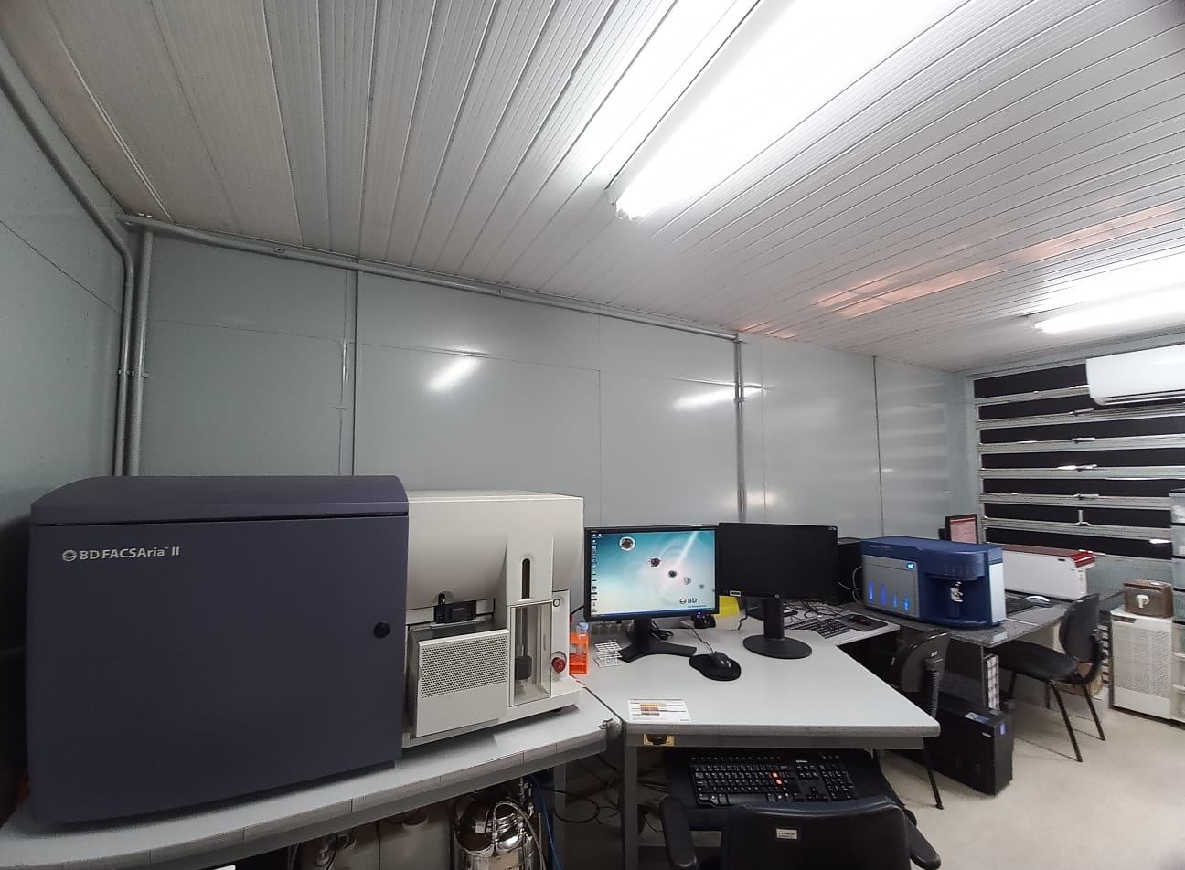 Sala de citometria com o separador de células BD FACSAria II e estações de análise