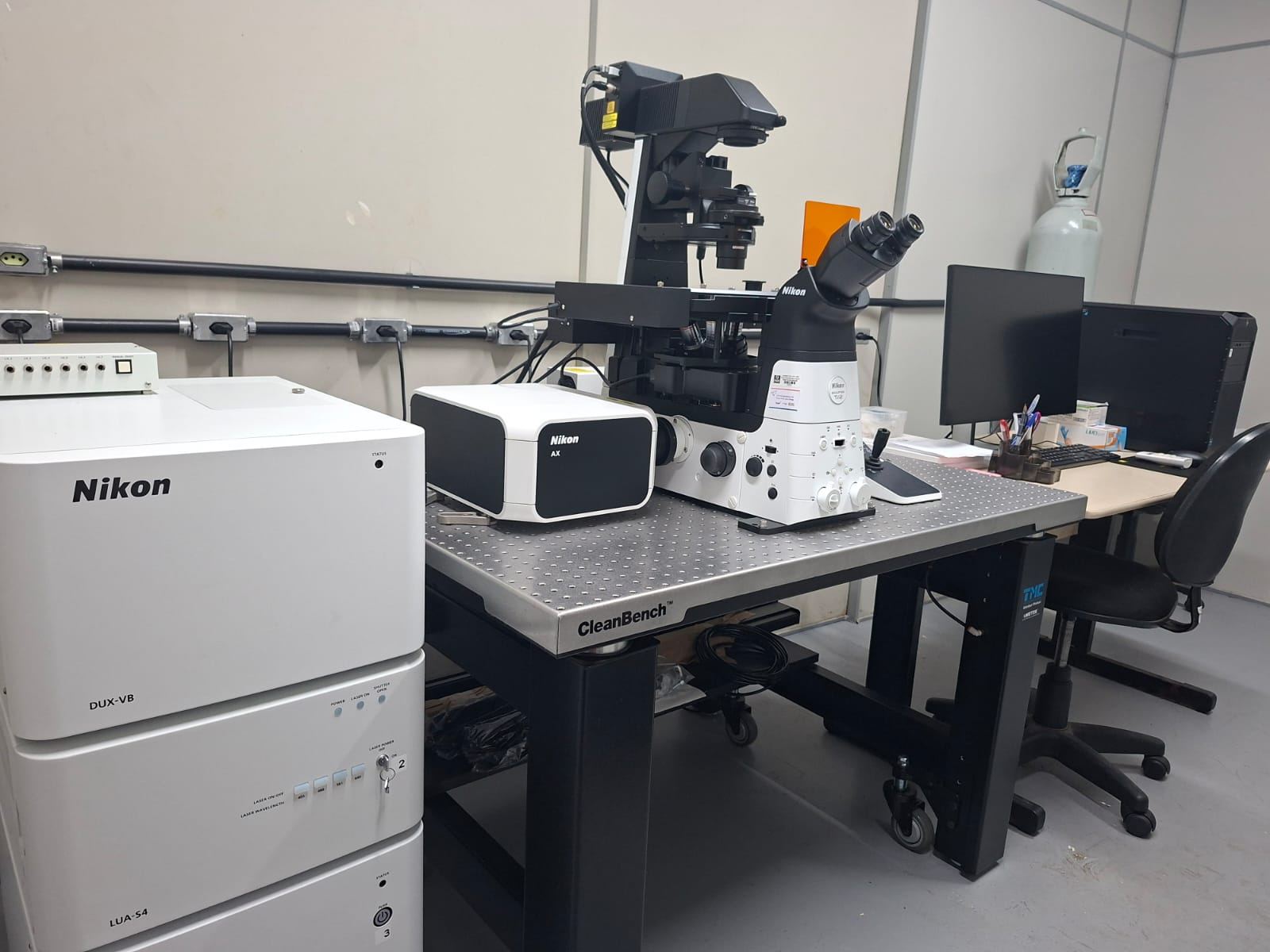 Microscópio confocal Nikon AX sobre mesa antivibração, com unidades de detecção e laser