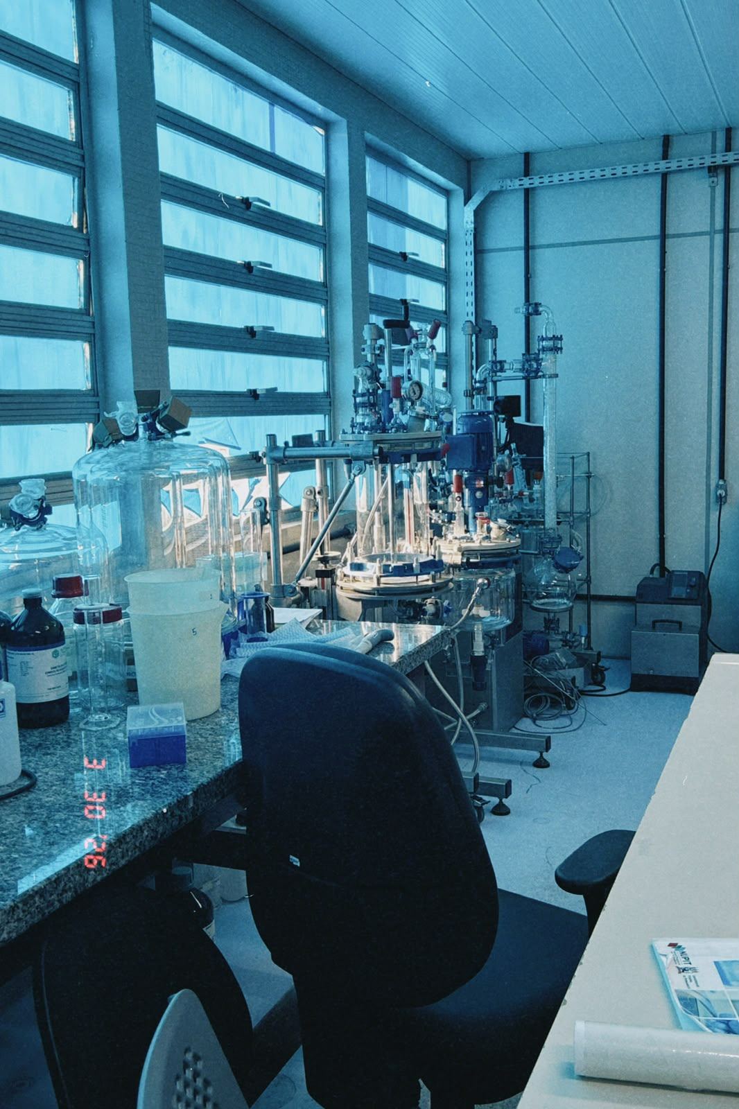 Bancada de laboratório de química com reatores e vidrarias