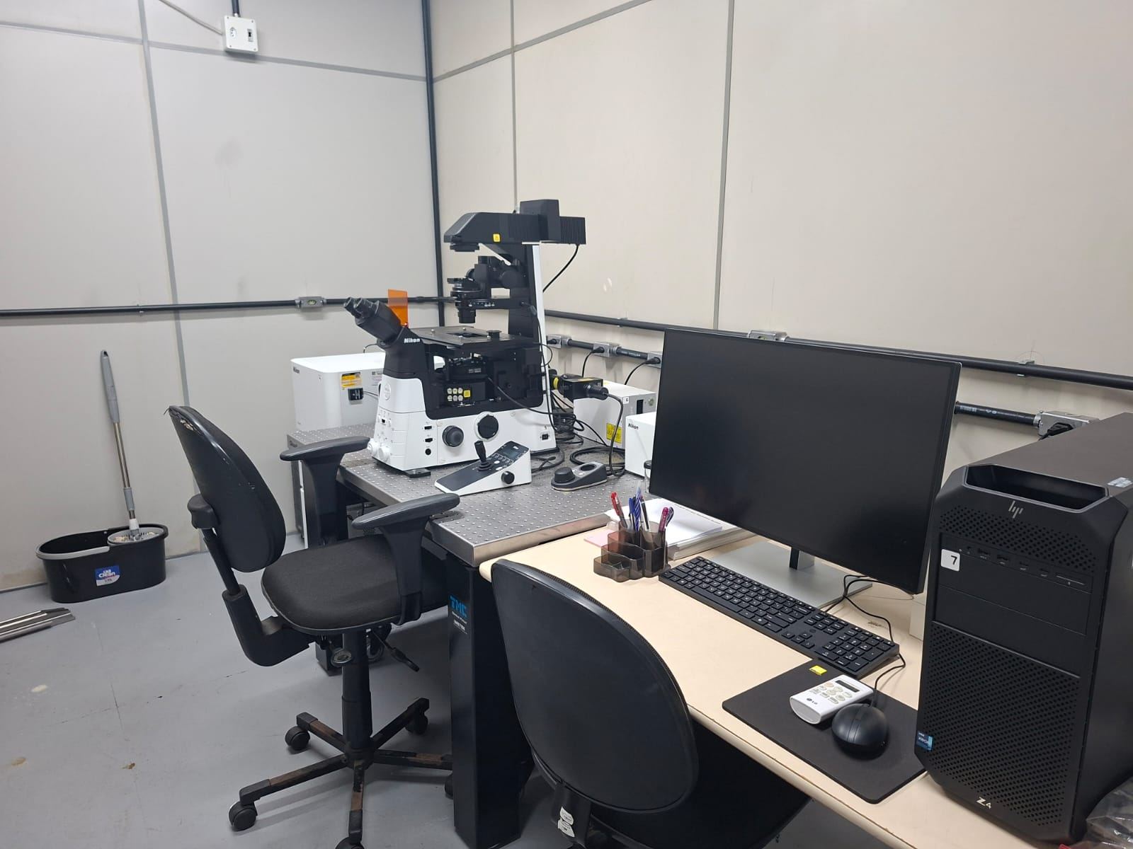 Estação de microscopia com computador, monitor e microscópio invertido